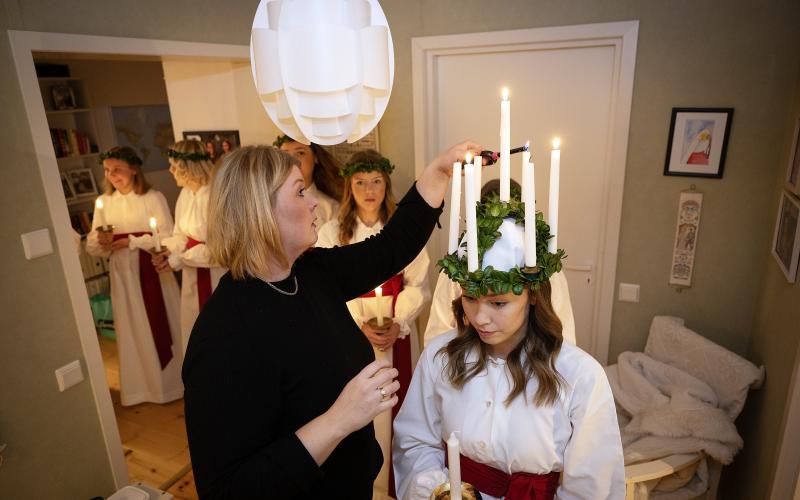 Alexandra Walk-Liljeroos tänder ljusen i lucia Stella Branérs krona.