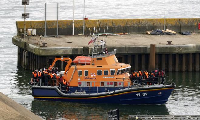 Händelsen sker samtidigt som Storbritanniens premiärminister Rishi Sunak vill avskräcka den farliga flyktingsmugglingen över Engelska kanalen. Bild på människor som tros vara migranter som förs till Dover i England.
