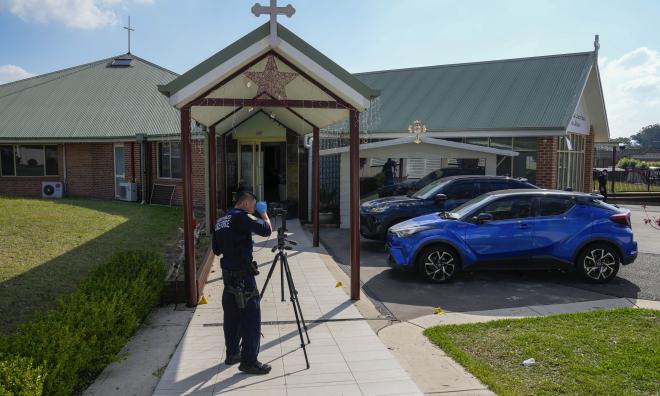 En polis framför kyrkan i Wakely i Sydneys utkanter, där knivhuggningen skedde.