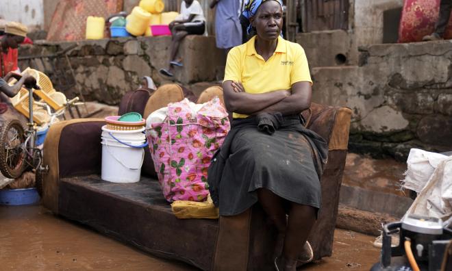 En kvinna sitter på en soffa utanför sitt översvämmade hus i den informella bosättningen Mathare i Kenyas huvudstad Nairobi.