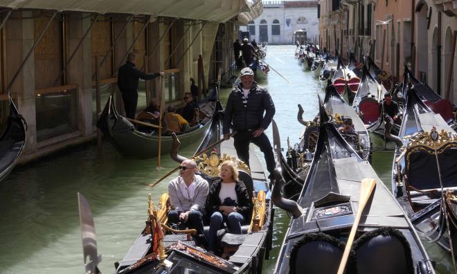 Turister i en gondol i Venedigs kanaler i april.