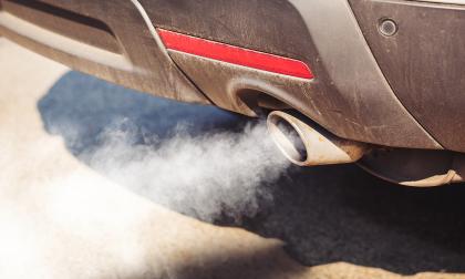 air pollution from dirty and aged vehicle exhaust pipe on road