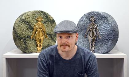 Konstnären Ville Heimala omgiven av sin Skogsmoder och Vattenmoder som visas på Galleriet under oktober. 