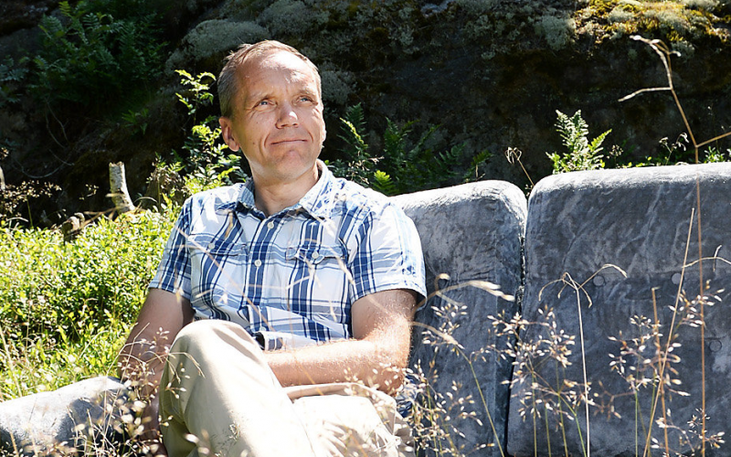 Björn Vikström sitter på en soffa i solskenet