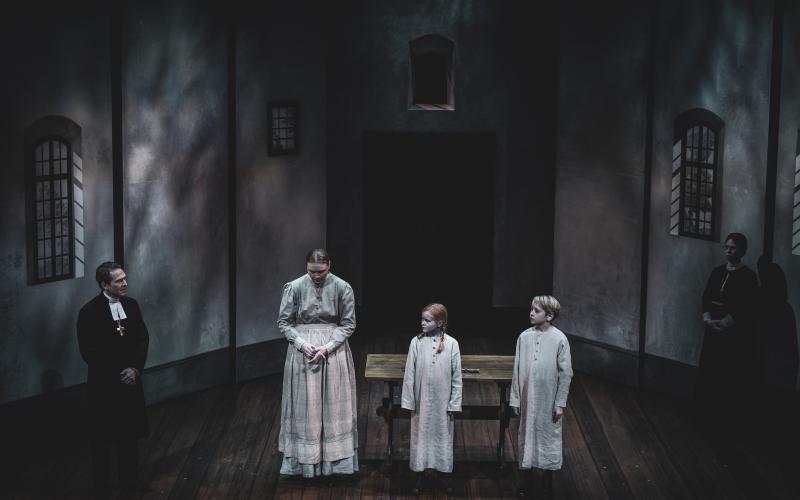 Som pigan Justina, som arbetar på biskopsgården, syns ålänningen Alice Stenberg ofta på scen i den andra akten av ”Fanny & Alexander” på Norrbottensteatern. Här flankeras hon av biskopen och barnen.