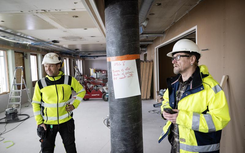 Micko Koskinen-Pahlman visar en bärande pelare, som är den första på Åland att förstärkas med kolfiber. ”Det var för lite armering för att det skulle gå att bygga på med två våningar”, säger han.Till vänster står Daniel Gustavsson.