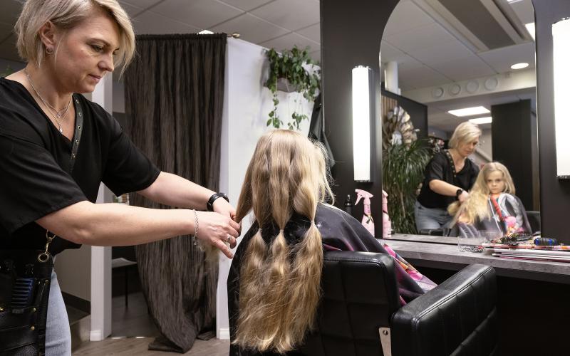 Marika Helin delar in Majas hår i flera tofsar som sedan ska flätas innan de klipps av.@Normal_indrag:<@Fotograf>Daniel Eriksson