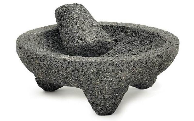 Nytillverkad mexikansk molcajete av vulkanisk sten. Innan den tas i användning bör den ”kuras” med salt, vatten och ris för att inte stenbitar och damm skall hamna i maten.