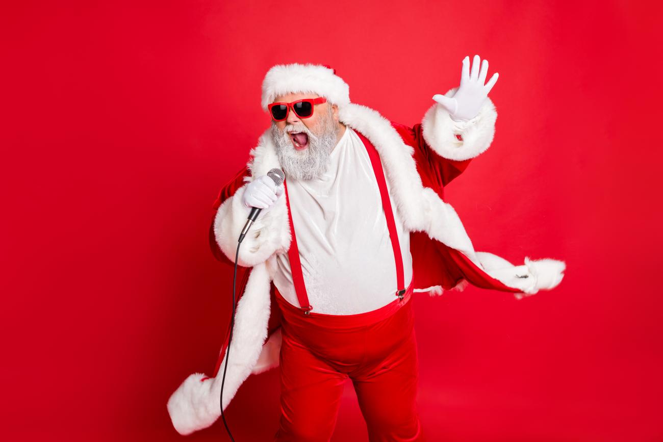 Portrait of cool funny fat overweight santa claus with big belly sing song on christmas party wear style stylish trendy eyeglasses eyewear, hat isolated over red background