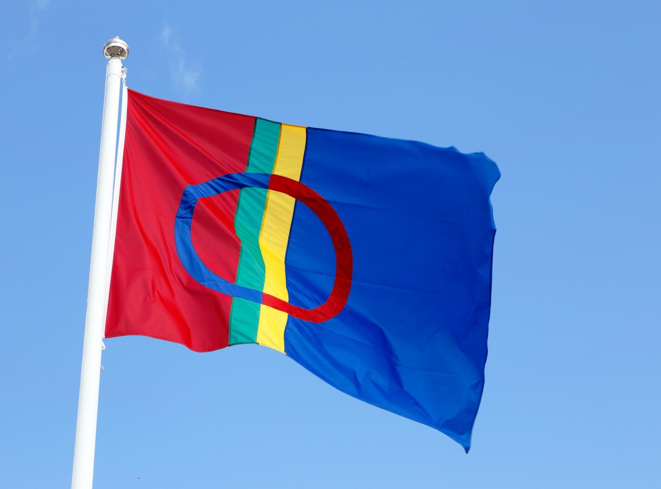The Sami flag isolated on clear blue sky.