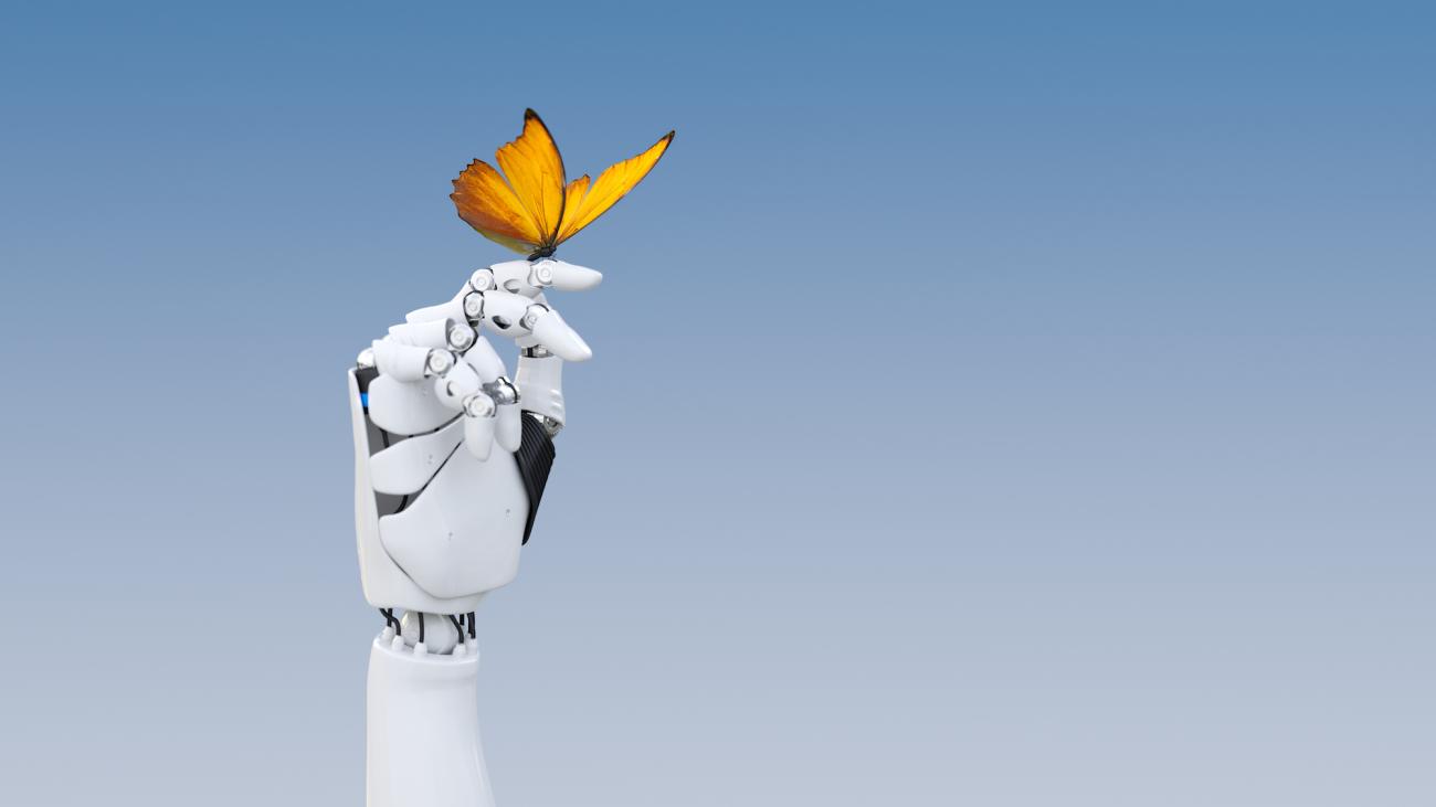 A yellow butterfly poised on a robot finger