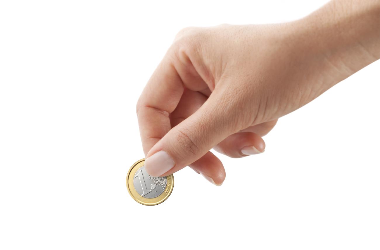 Woman hand holding one euro coin isolated on white background.