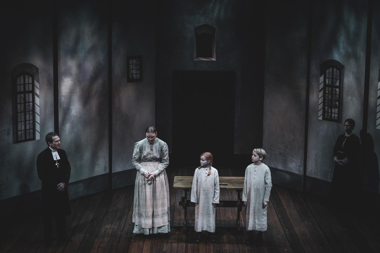 Som pigan Justina, som arbetar på biskopsgården, syns ålänningen Alice Stenberg ofta på scen i den andra akten av ”Fanny & Alexander” på Norrbottensteatern. Här flankeras hon av biskopen och barnen.