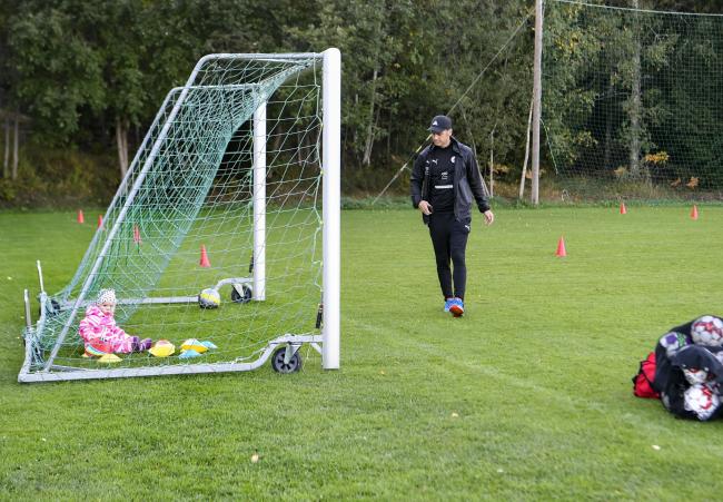 Malva Björklund är bara ett år men redan van vid att vara med vid fotbollsplanen. Pappa Fredrik Björklund ställer ut koner inför träningen.